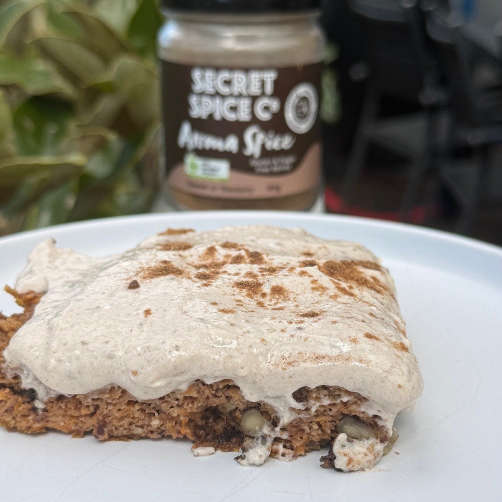 carrot cake recipe with yoghurt topping next to glass jar of Secret Spice Co Aroma blend